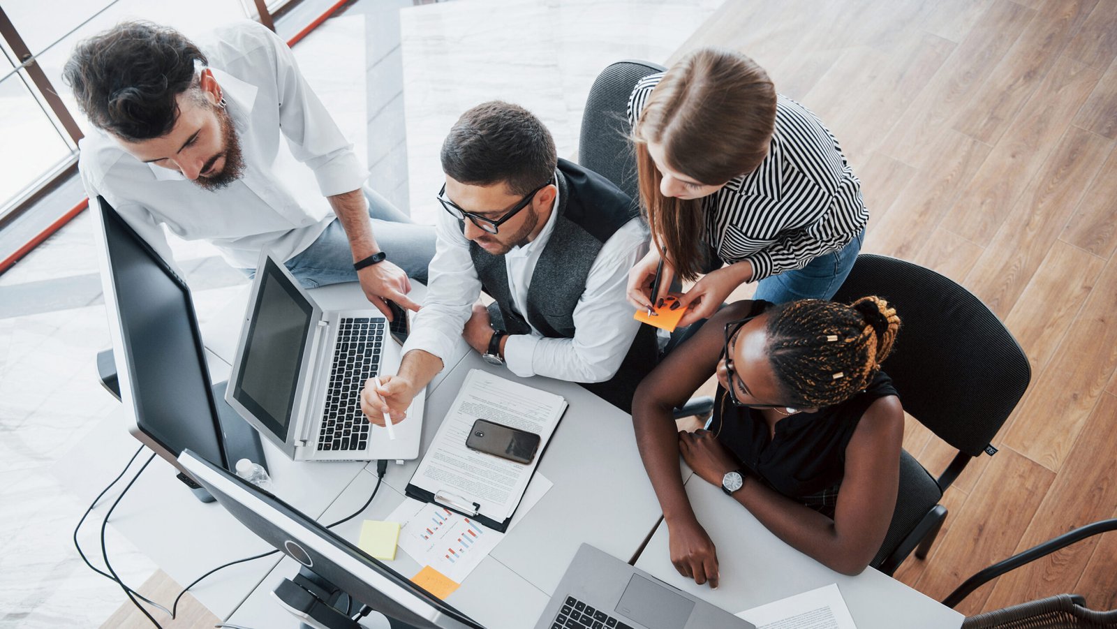 Controle de internet - Equipe reunida em escritório analisando informações no computador, representando produtividade, colaboração e gestão do uso da tecnologia.